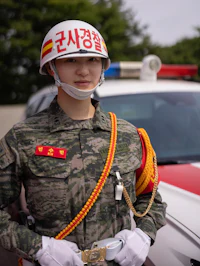 a woman in uniform standing next to a police car